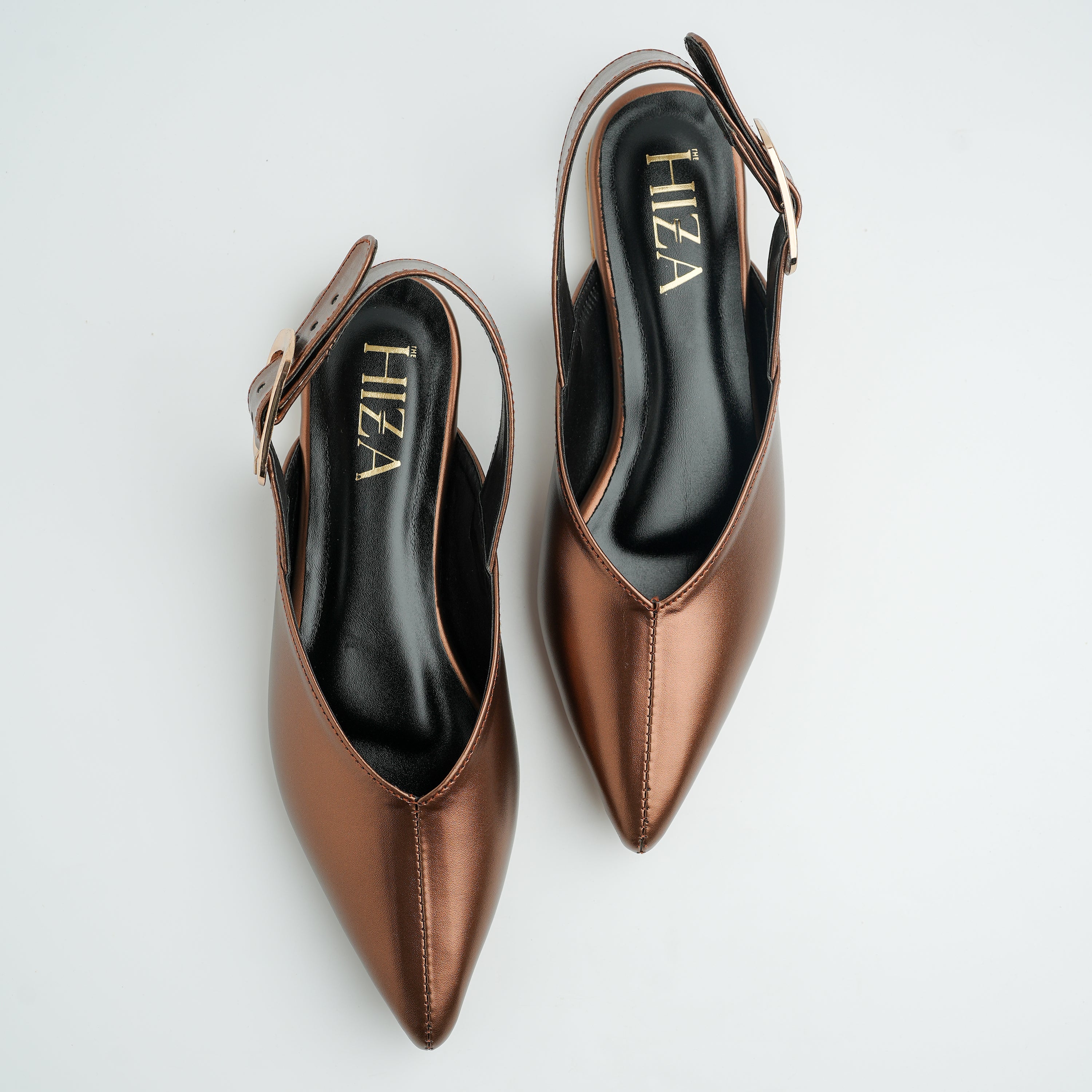 Pair of brown pointed-toe shoes with slingback design on a light gray background